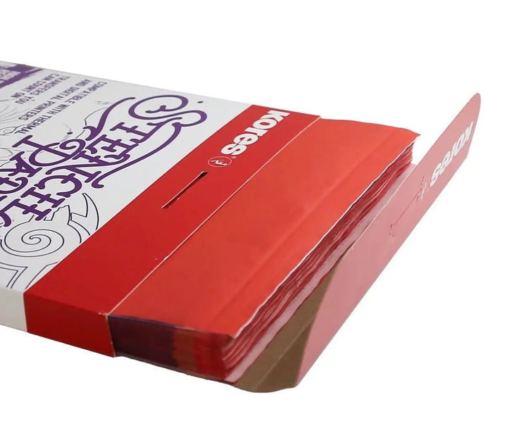Kores Carbon &amp; Ribbon tattoo stencil paper box shown at an angle, displaying the stacked red perforated backing sheets.