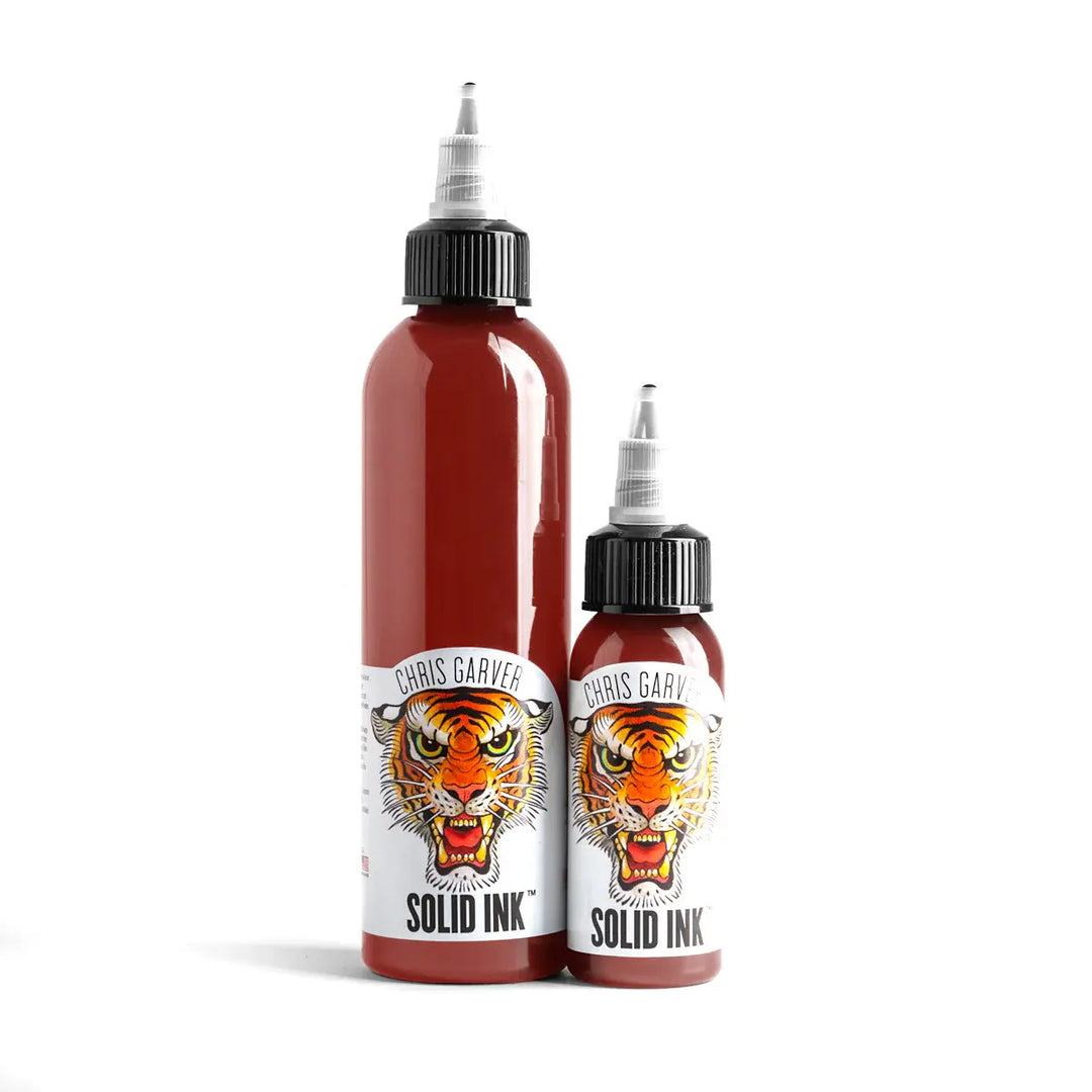Two bottles of Chris Garver Solid Ink with tiger design labels on a white background